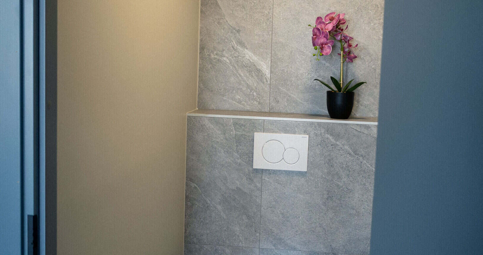 Minimalistlik WC Päti mängustuudio interjööris, roosad lilled ja modernne disain.